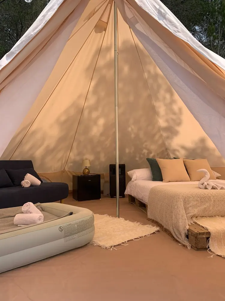 Glamping bell tent interior — double bed and cozy atmosphere in Ibiza