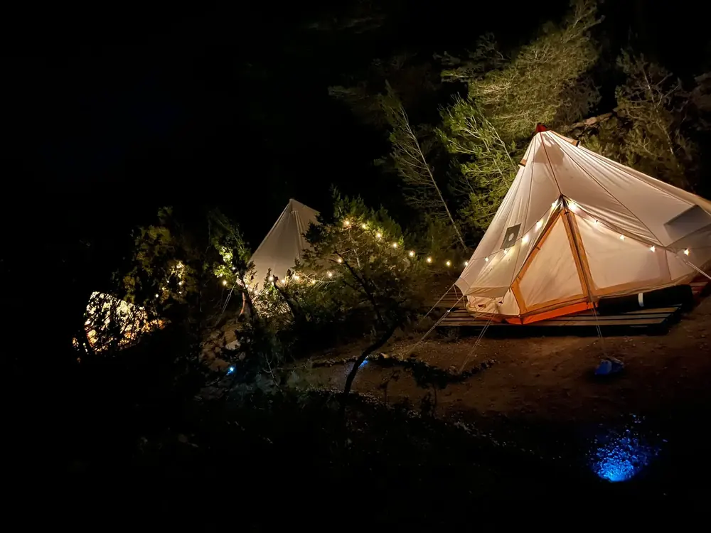 Glamping bell tents glowing at night with fairy lights — Ibiza glamping