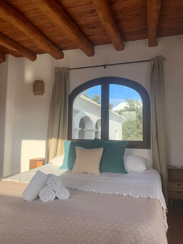 Charming finca bedroom with arched window and wooden beams — Ibiza